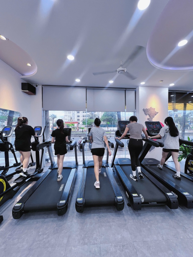 Các hội viên nữ đang tập luyện trên máy chạy bộ hiện đại tại HerFit